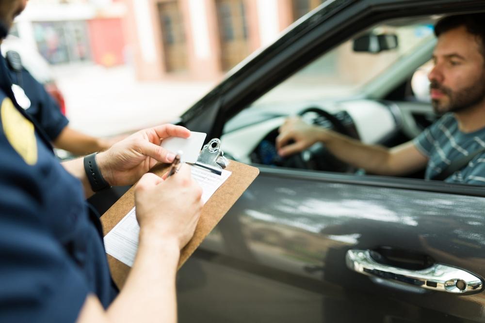 Close up of a police cop writing a traffic ticket