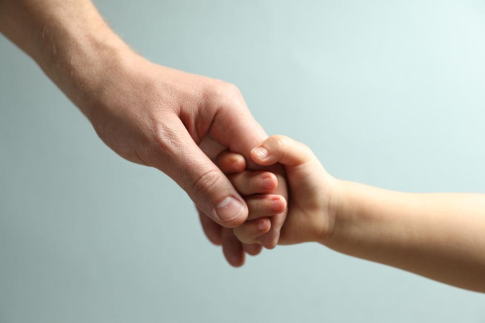 Father and child holding hands