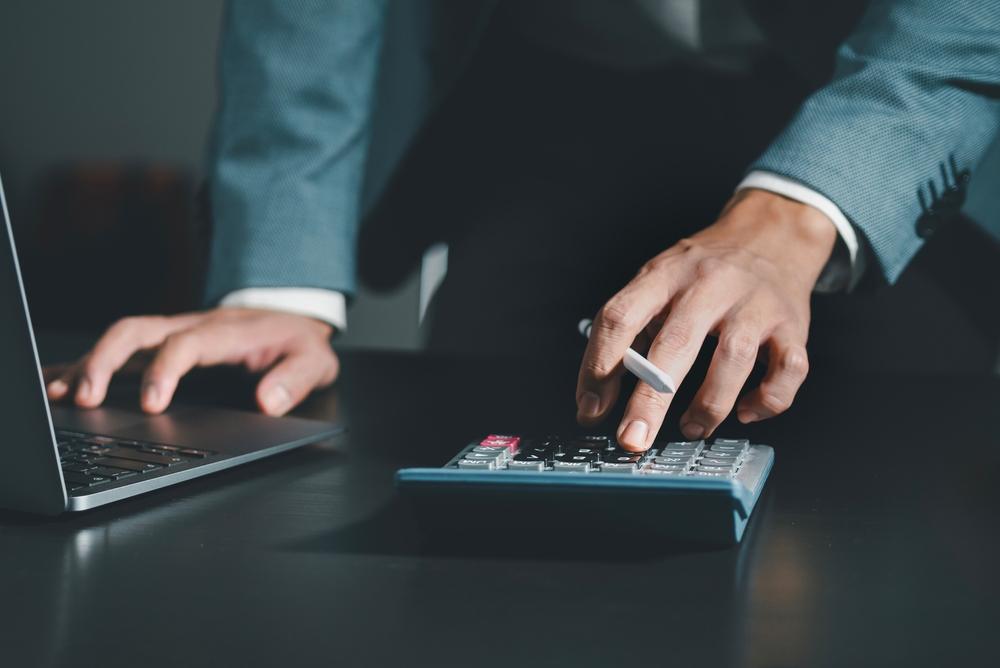 business using calculator to calculate financial reports