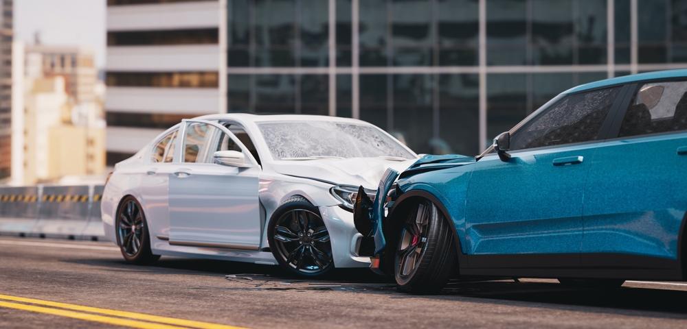 Two damaged cars facing each other on the road after a Lyft accident.
