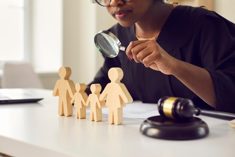 lawyer looking in magnifying glass at figures on desk