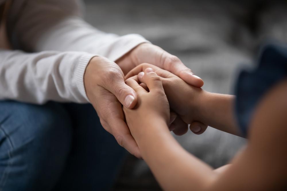 parent holding hands of little kid